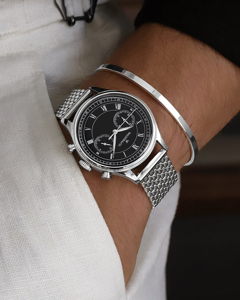 A round mens watch in rhodium-plated silver from Waldor & Co. with black sunray dial and a second hand. Seiko movement. The model is Avant 42 Sardinia 42mm.