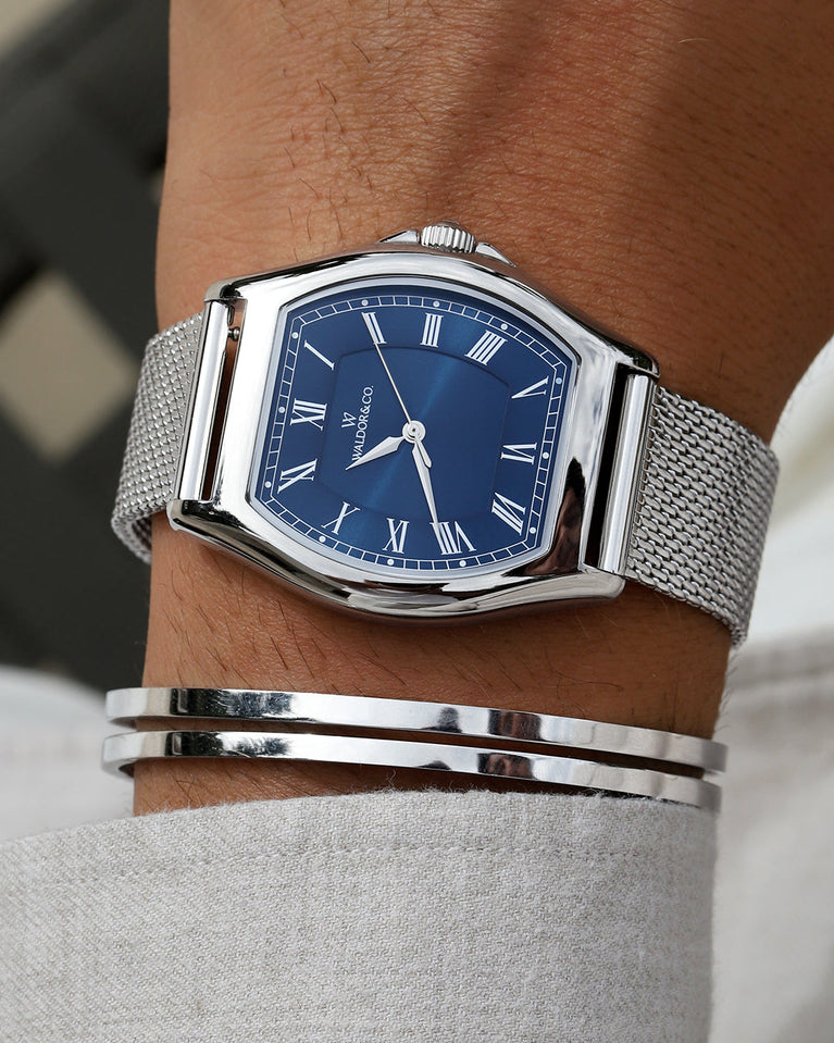 A tonneau mens watch in rhodium-plated silver from Waldor & Co. with blue sunray dial and a second hand. Ronda movement. The model is Constant 40 Lecco.