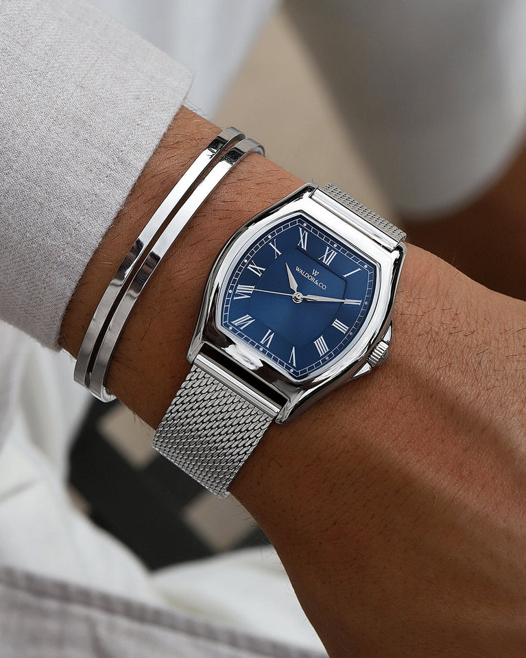 A tonneau mens watch in rhodium-plated silver from Waldor & Co. with blue sunray dial and a second hand. Ronda movement. The model is Constant 40 Lecco.