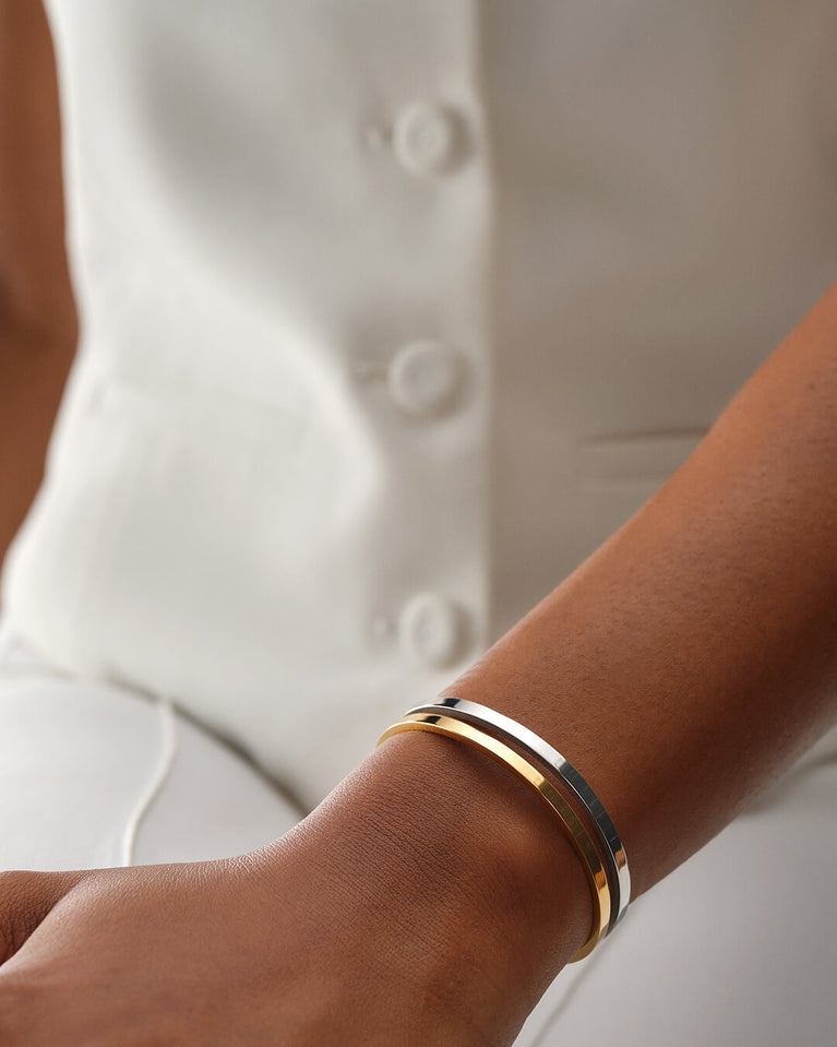 A Bangle in polished silver 316L stainless steel from Waldor & Co. One size. The model is Dual Bangle Polished.