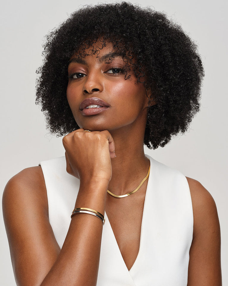 A Bangle in polished silver 316L stainless steel from Waldor & Co. One size. The model is Dual Bangle Polished.