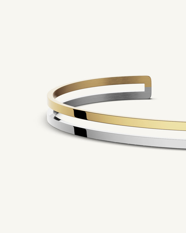 A Bangle in polished silver 316L stainless steel from Waldor & Co. One size. The model is Dual Bangle Polished.