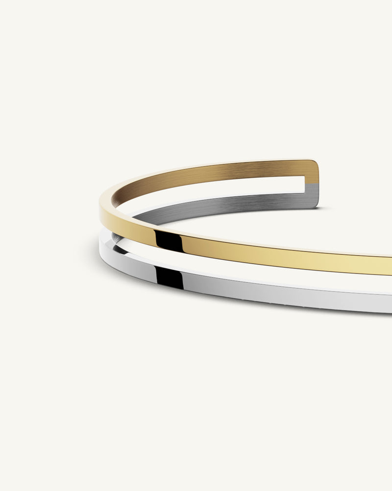 A Bangle in polished silver 316L stainless steel from Waldor & Co. One size. The model is Dual Bangle Polished.