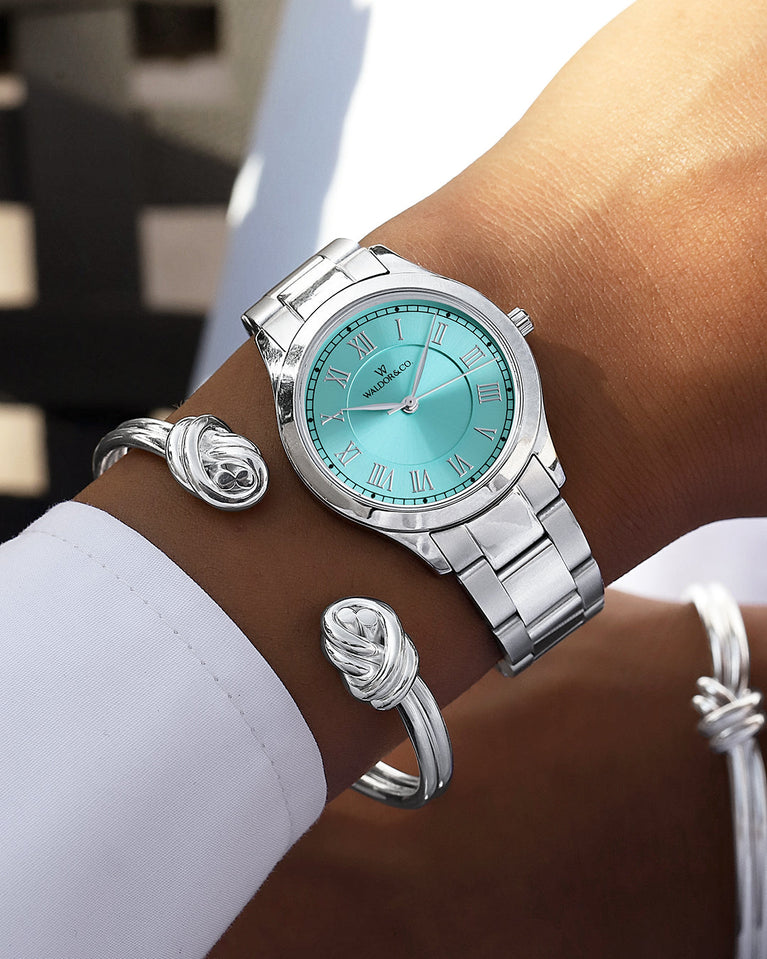 A round womens watch in silver from Waldor & Co. with turquoise sunray dial and a second hand. Seiko movement. The model is Imperial 32 Nocelle 32mm.