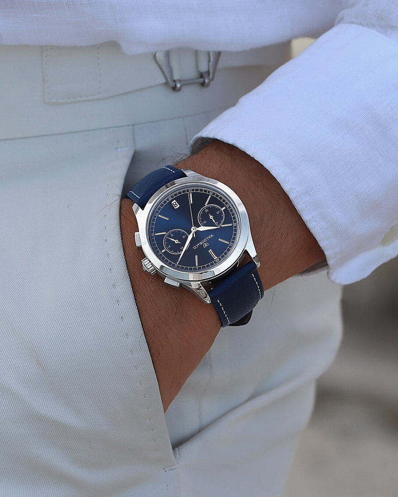 A round mens watch in rhodium-plated silver from Waldor & Co. with blue sunray dial and genuine blue leather strap. A second hand. Seiko movement. The model is Chrono 39 Sardinia 39mm.