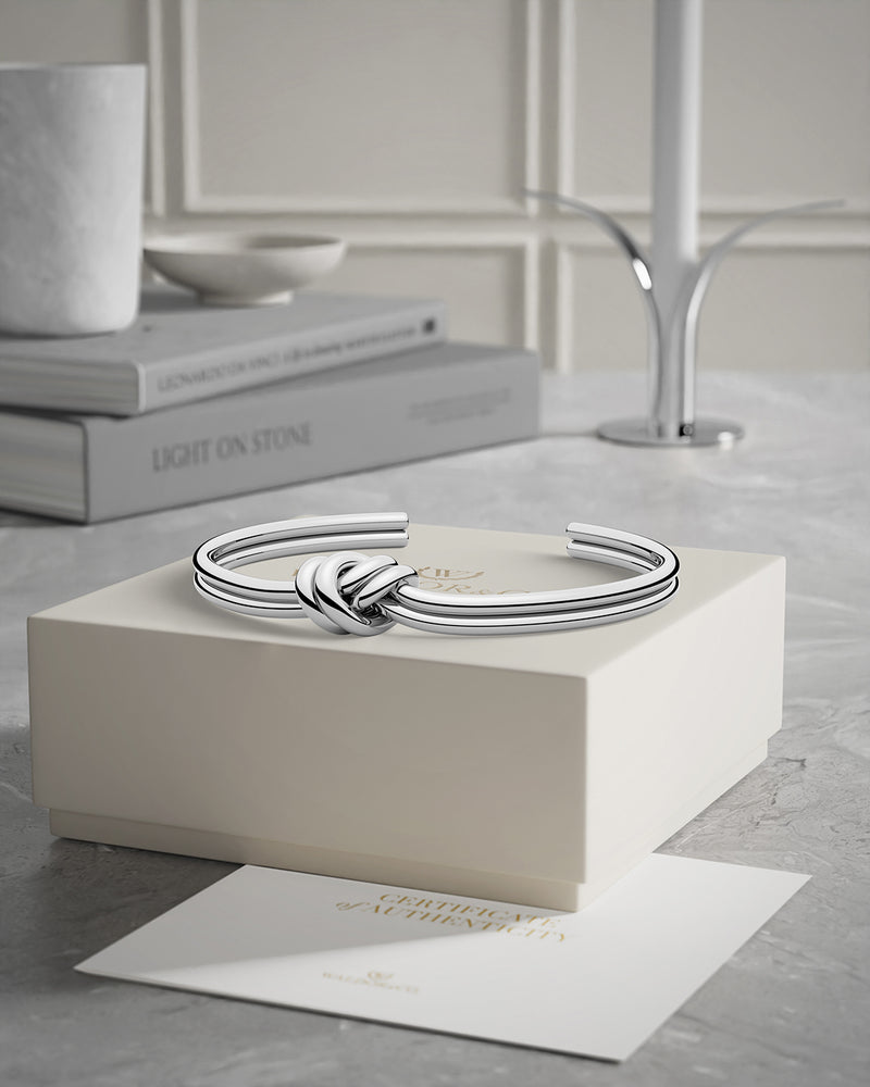 A Bangle Bracelet in polished Silver plated-316L stainless steel from Waldor & Co. The model is Dual Knot Bangle Polished.