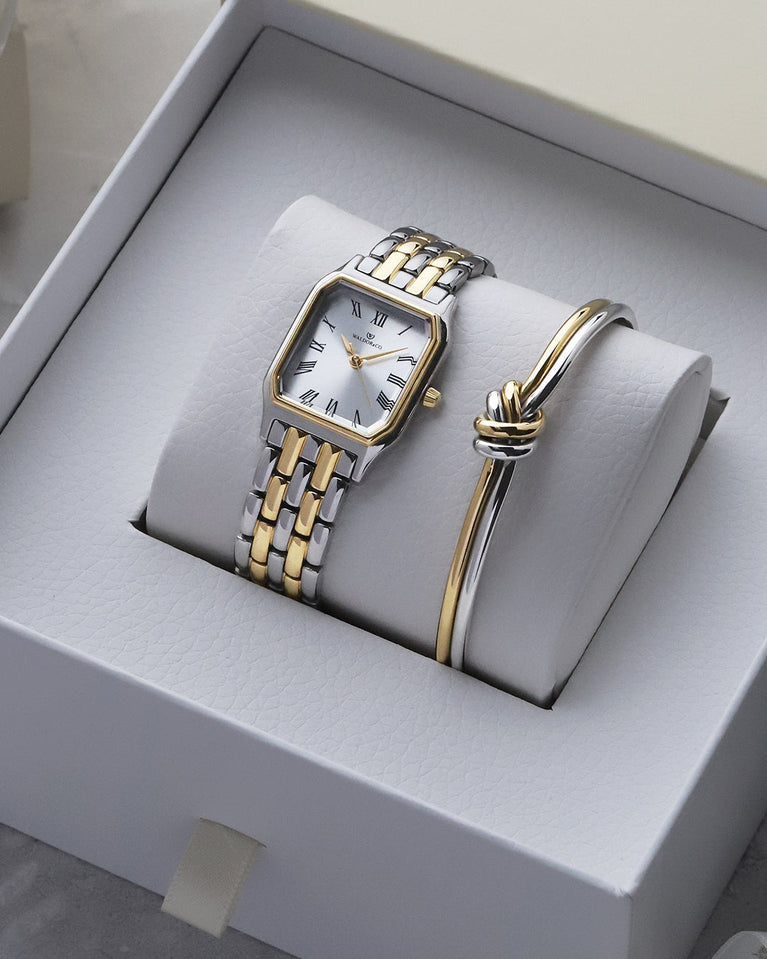 A square women’s watch and double knot bracelet in gold and silver from Waldor & co. The model is Eternal 22 Bellagio & Dual Knot Bangle.