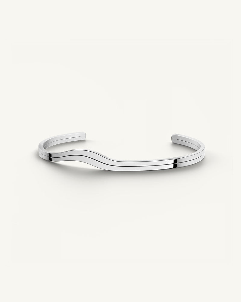 A polished stainless steel bangle in silver from Waldor & Co. One size. The model is Azur Bangle Polished.