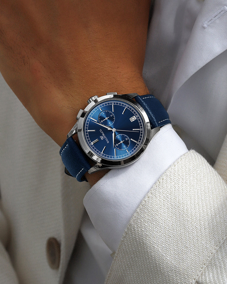A round mens watch in rhodium-plated silver from Waldor & Co. with blue sunray dial and genuine blue leather strap. A second hand. Seiko movement. The model is Chrono 44 Sardinia 44mm.