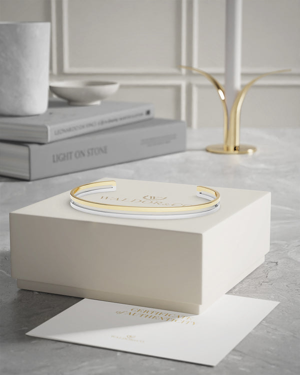  A bangle in 14k gold-plated 316L stainless steel from Waldor & Co. One size. The model is Dual Bangle Polished. 