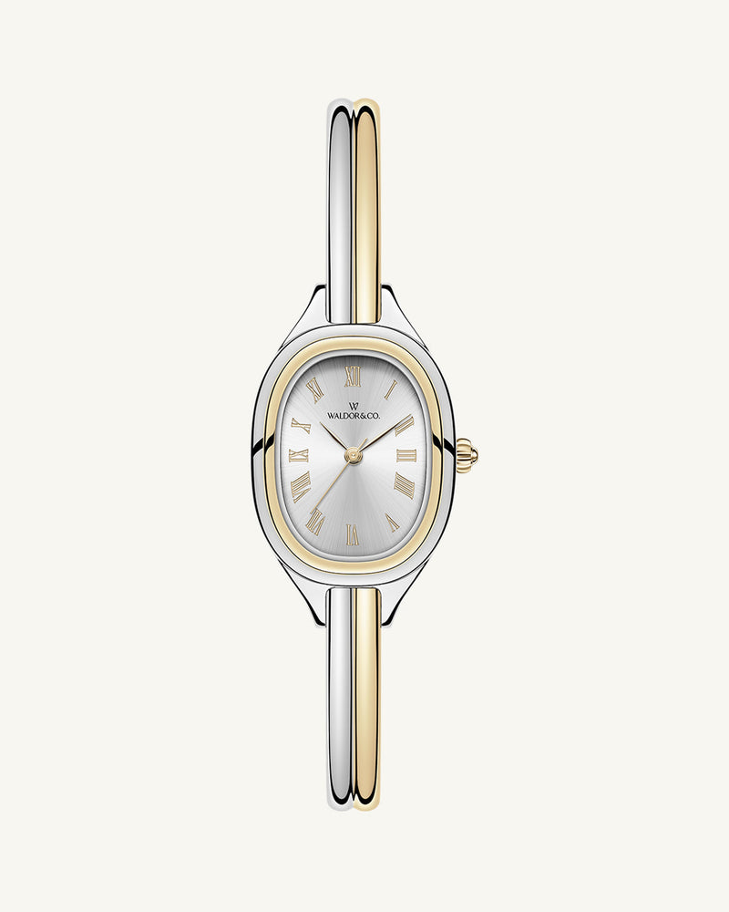 An ellipse shaped womens watch in Rhodium-plated 316L stainless steel from Waldor & Co. with silver sunray dial in brass. Mineral glass with sapphire crystal coating. Seiko movement. The model is Dual Bangle Watch.