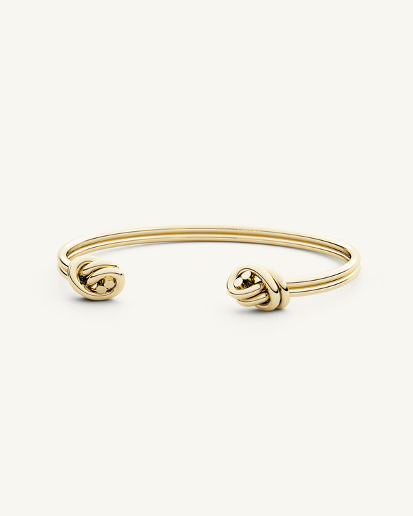 A Bangle in 14k-gold plated 316L stainless steel from Waldor & Co. One size. The model is Dual Knot Twin Bangle Polished.