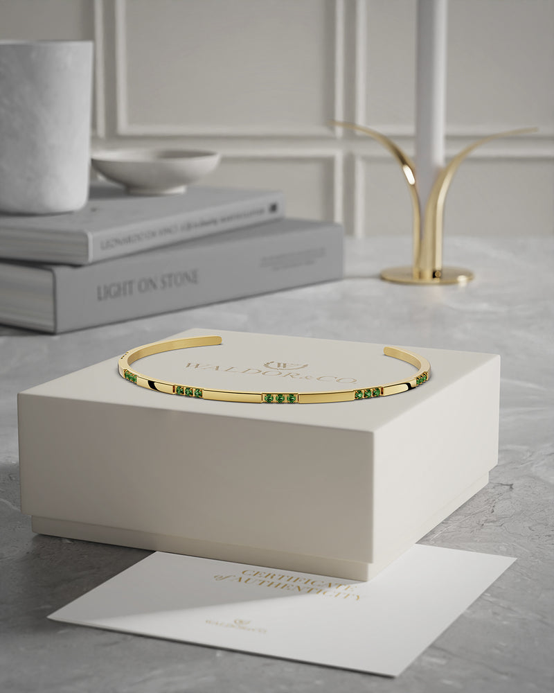 A Bangle in 14k gold-plated 316L stainless steel with green stones from Waldor & Co. One size. The model is Opulent Bangle Polished.