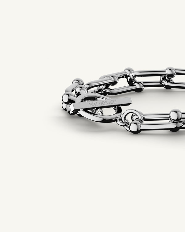 A Chain Bracelet in Rhodium-plated 316L stainless steel from Waldor & Co. The model is Pivot Chain Polished Gold