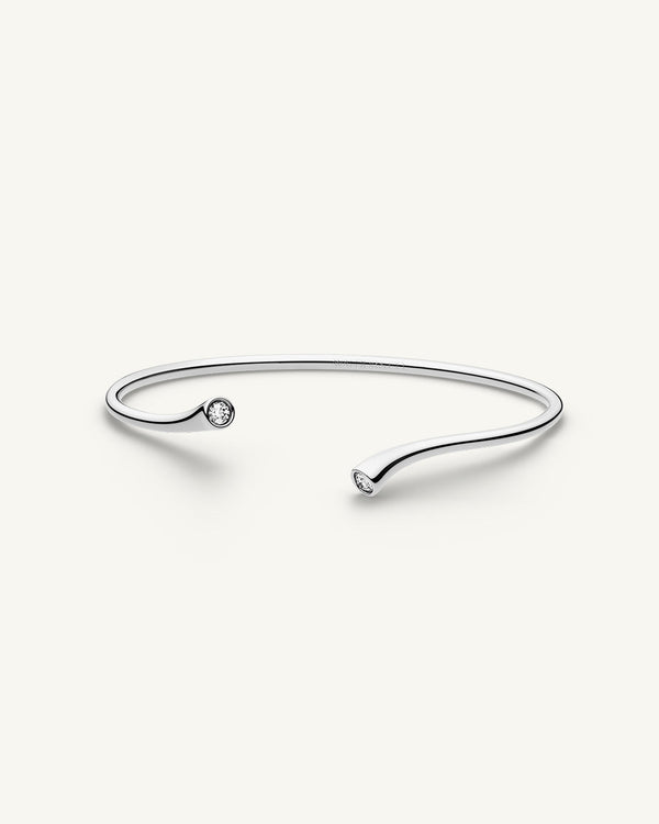 A polished stainless steel bangle from Waldor & Co. One size. The model is Delight Bangle. 