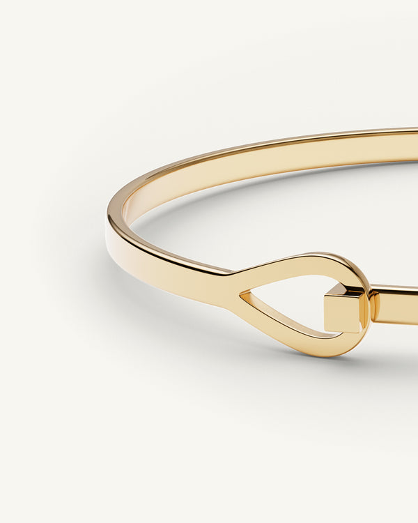 A Bangle Bracelet in 14k gold-plated from Waldor & Co. The model is Signature Bangle Polished Gold