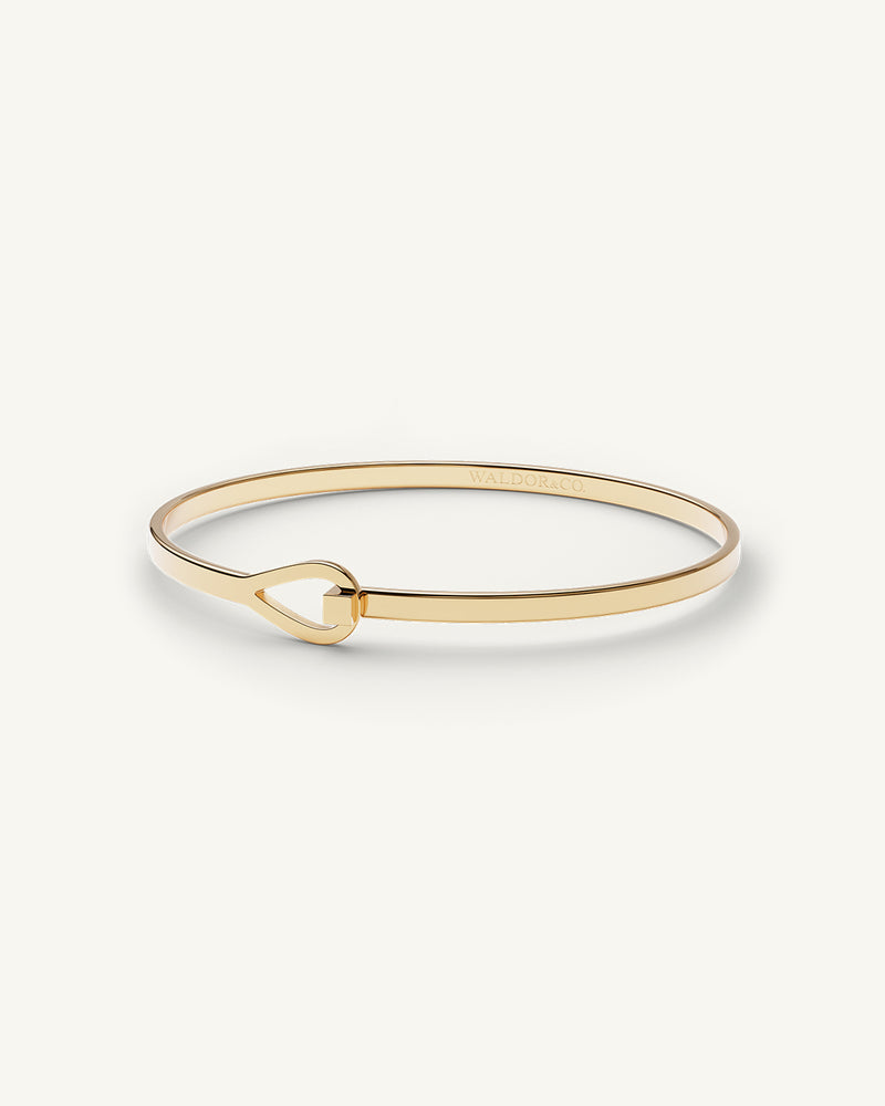 A Bangle in 14k gold plated 316L stainless steel from Waldor & Co. One size. The model is Signature Bangle Polished.