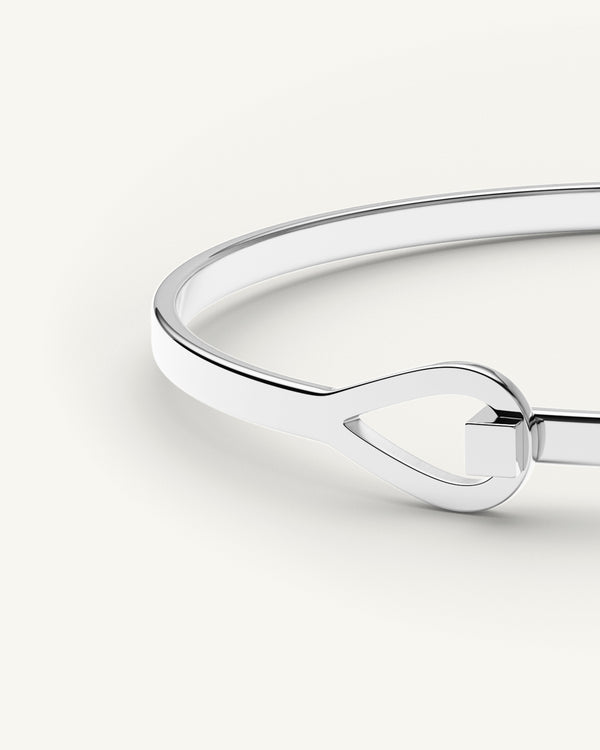 A polished stainless steel bangle in silver from Waldor & Co. The model is Signature Bangle Polished