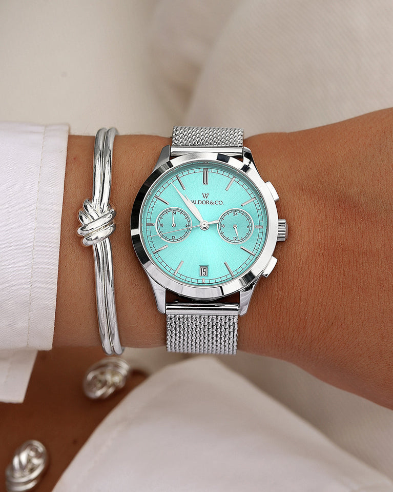  A round womens watch in rhodium-plated silver from Waldor & Co. with turquoise sunray dial and a second hand. Seiko movement. The model is Chrono 36 Sardinia 36mm.
