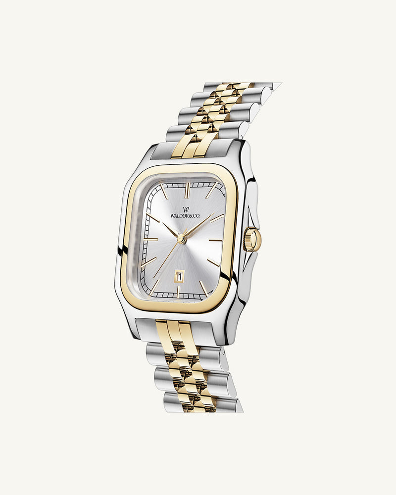 A square womens watch in silver and 14k gold from Waldor & Co. with silver sunray dial and a second hand. Seiko movement. The model is Delight 32 Chelsea 28x32mm.