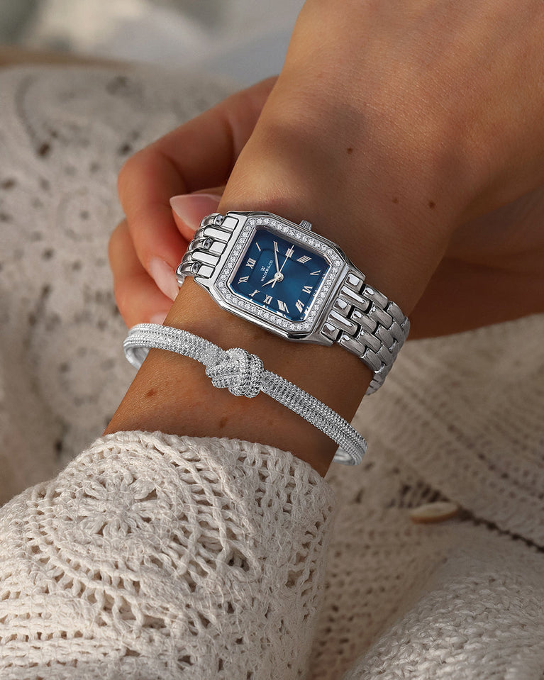 A square womens watch in Rhodium-plated 316L stainless steel from Waldor & Co. with dark blue dial. Bezel with premium crystals. Diamond Cut Sapphire Crystal glass dial. Seiko movement. The model is Eternal 22 Bellagio Pavè.